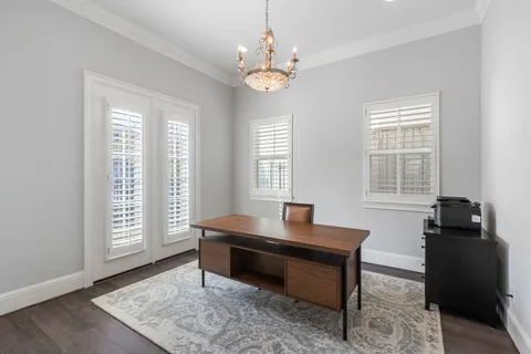 a reading room with wooden floor and windows