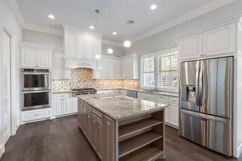 a kitchen with a stove refrigerator and microwave