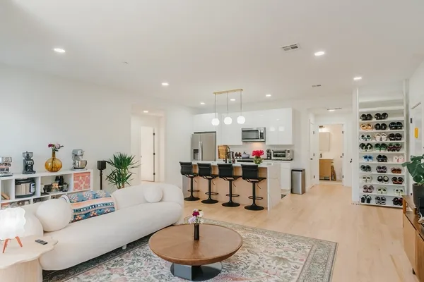 a living room with furniture and a dining table with kitchen view