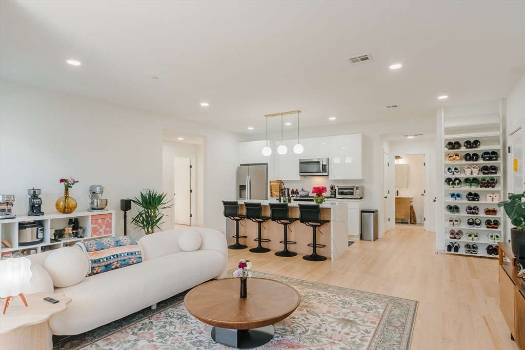 a living room with furniture and a dining table with kitchen view