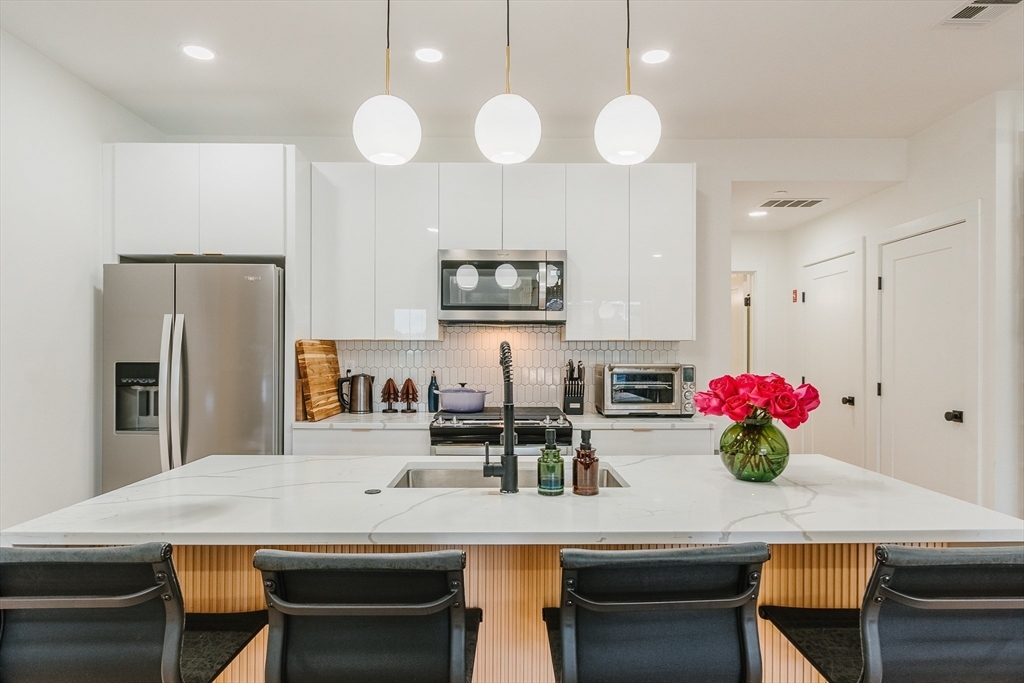 43 Withington Street, Unit 7 Boston, MA 02124 - Photo 4 of 21 a kitchen with cabinets table and chairs
