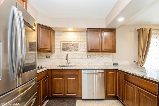 a kitchen with granite countertop stainless steel appliances a sink and cabinets
