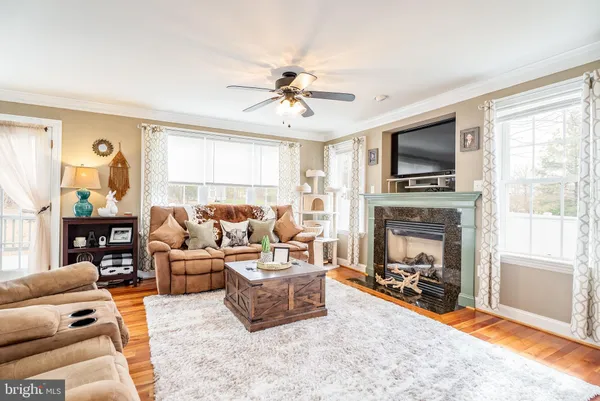 a living room with furniture kitchen view and a large window