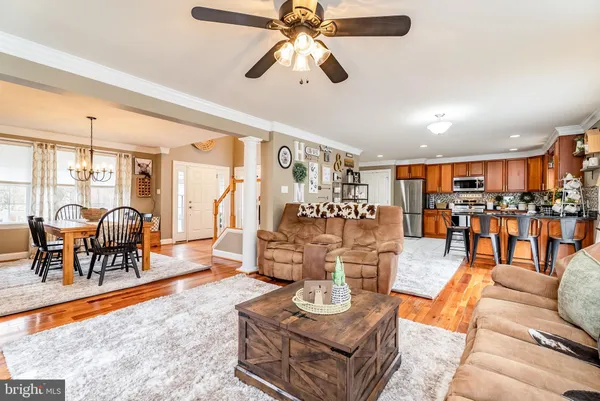a kitchen with stainless steel appliances granite countertop a refrigerator a stove a sink dishwasher a dining table and chairs with wooden floor