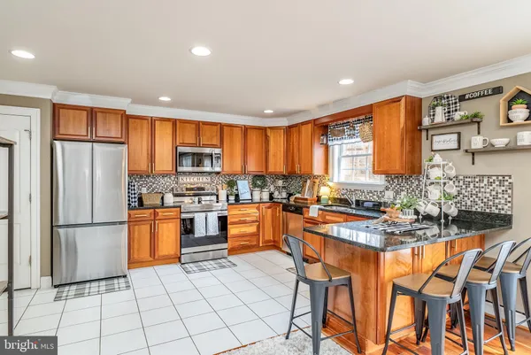 a kitchen with stainless steel appliances granite countertop sink window and white cabinets