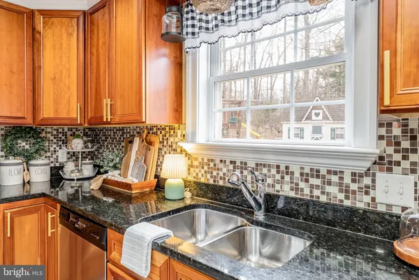 a kitchen with stainless steel appliances kitchen island granite countertop a refrigerator and cabinets