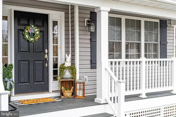 a view of a dining room and livingroom with furniture wooden floor a rug a chandelier
