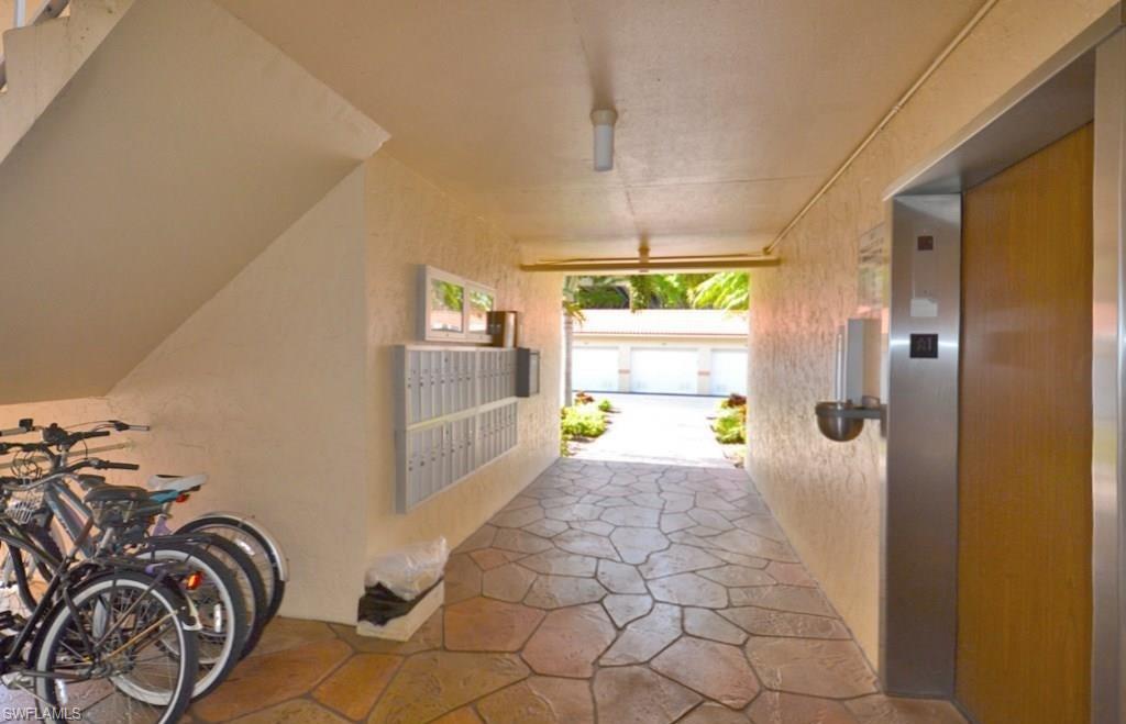 307 Goodlette-Frank Road, Unit 506B Naples, FL 34102 - Photo 21 of 25 a view of a hallway with a dining table & chairs