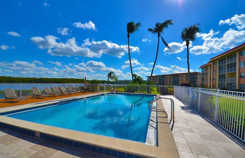307 Goodlette-Frank Road, Unit 506B Naples, FL 34102 - Photo 22 of 25 a view of a swimming pool with a lounge chairs