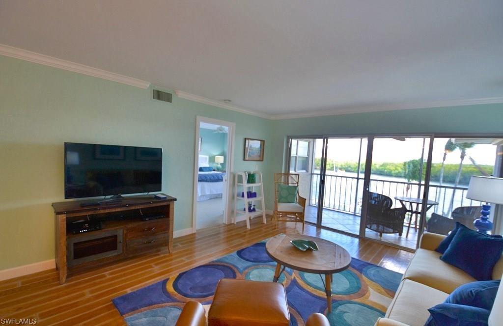 307 Goodlette-Frank Road, Unit 506B Naples, FL 34102 - Photo 6 of 25 a living room with furniture and a flat screen tv