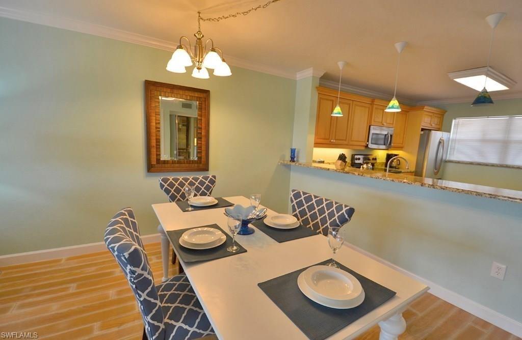 307 Goodlette-Frank Road, Unit 506B Naples, FL 34102 - Photo 8 of 25 a view of a dining room with furniture and chandelier