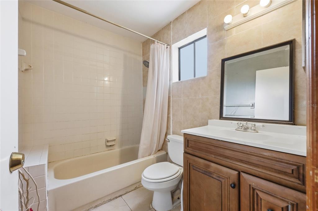 3027 Queens Gate Road Orlando, FL 32818 - Photo 24 of 34 a bathroom with a sink a toilet and a bathtub