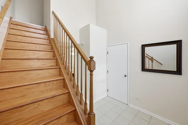 a view of staircase with wooden floor and white walls
