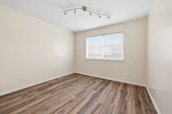 a view of a room with wooden floor closet and windows