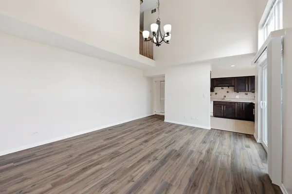 a view of a room with wooden floor and a kitchen