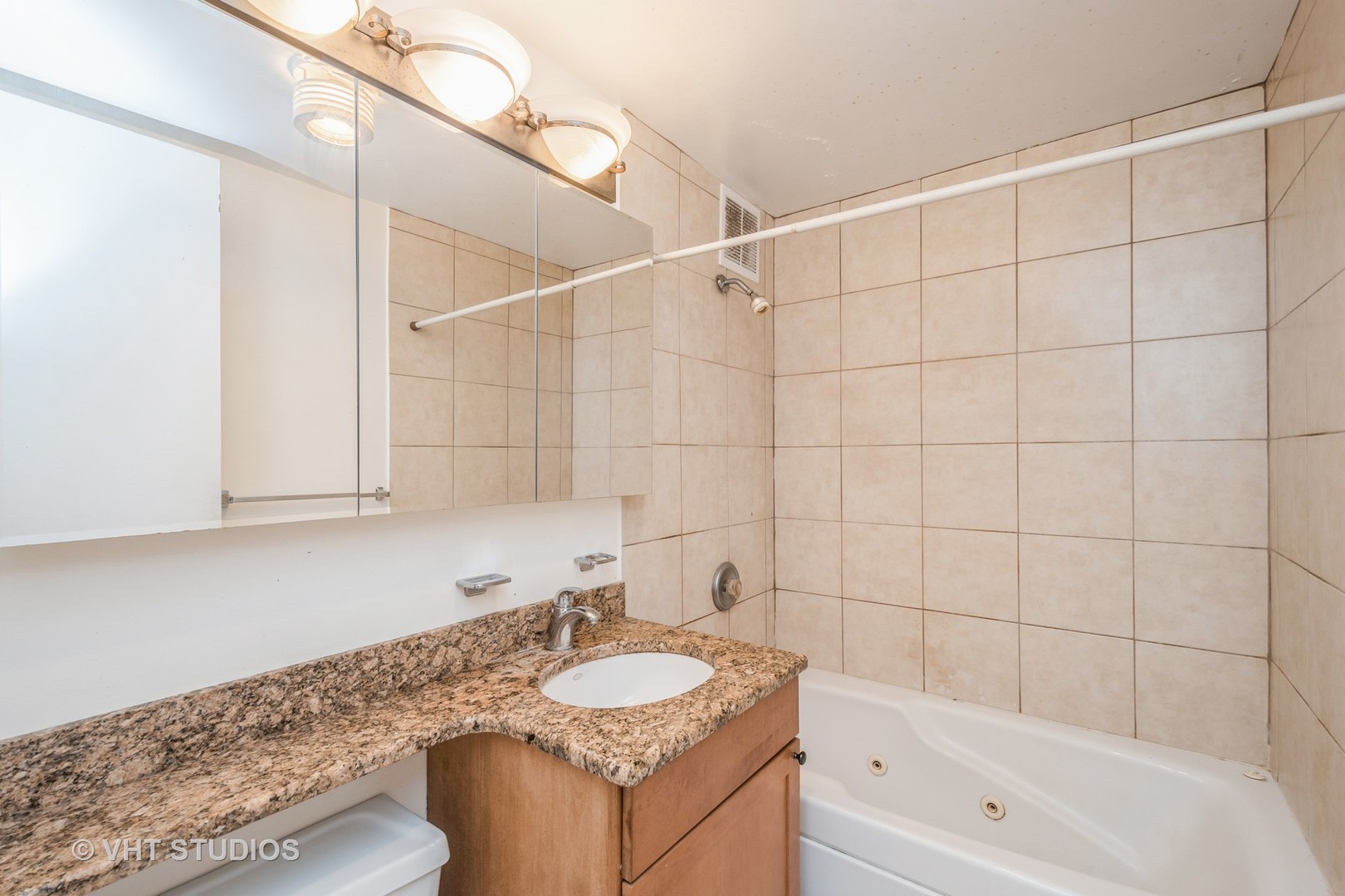 655 West Irving Park Road, Unit 4915 Chicago, IL 60613 - Photo 11 of 17 a bathroom with a granite countertop sink and a bathtub