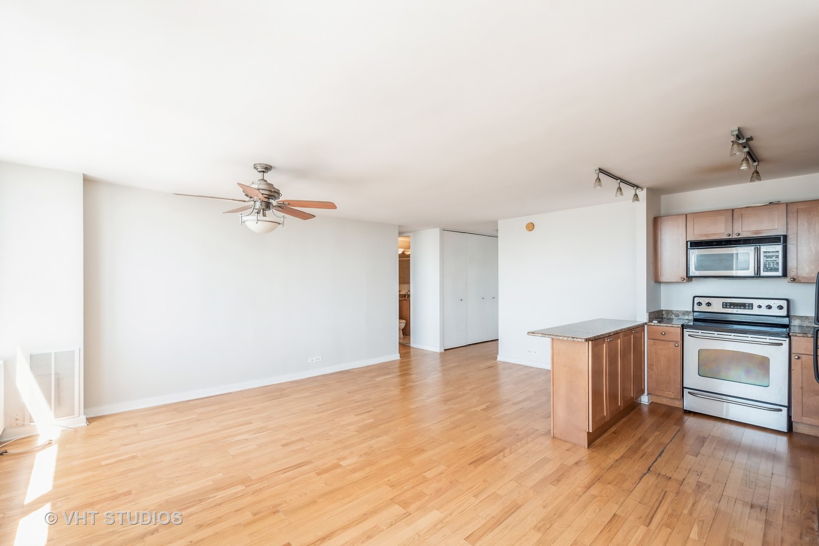 655 West Irving Park Road, Unit 4915 Chicago, IL 60613 - Photo 7 of 17 a view of a kitchen with a sink a ceiling fan and wooden floor