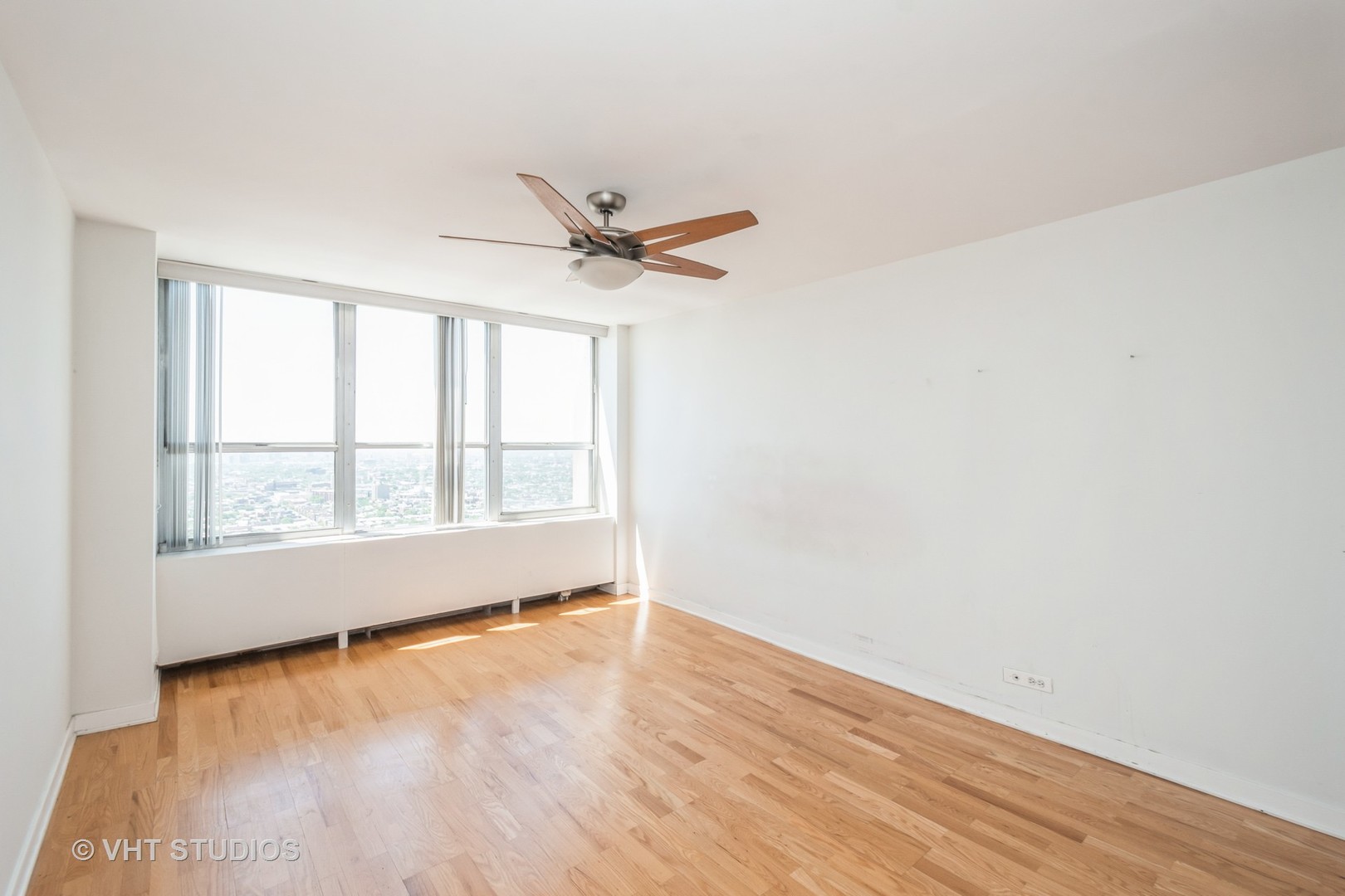 655 West Irving Park Road, Unit 4915 Chicago, IL 60613 - Photo 9 of 17 an empty room with wooden floor and windows