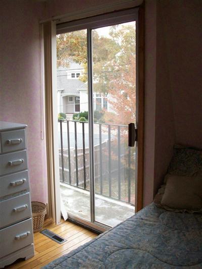 9 Spoondrift Circle Mashpee, MA 02649 - Photo 18 of 21 a bedroom with a bed and glass door