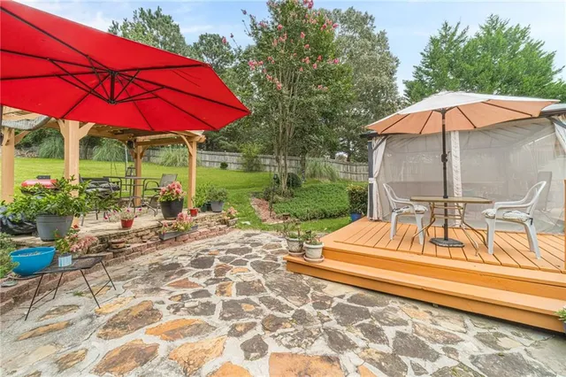 a view of a patio with table and chairs under an umbrella