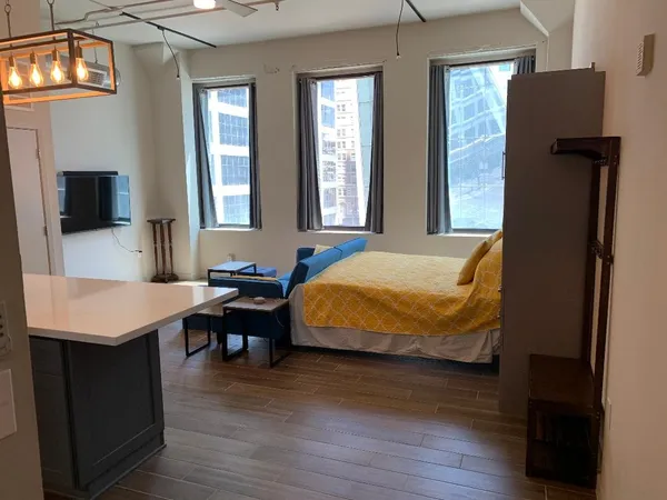 a bedroom with a bed and wooden floor