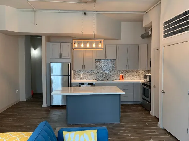 a kitchen with kitchen island white cabinets and stainless steel appliances