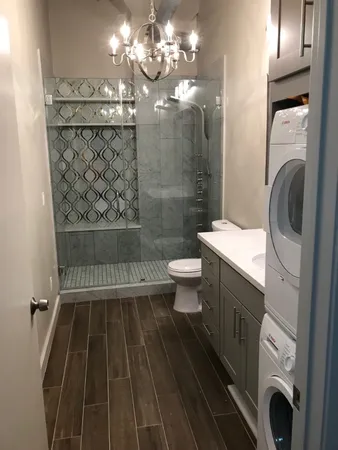 a bathroom with a sink a toilet and shower