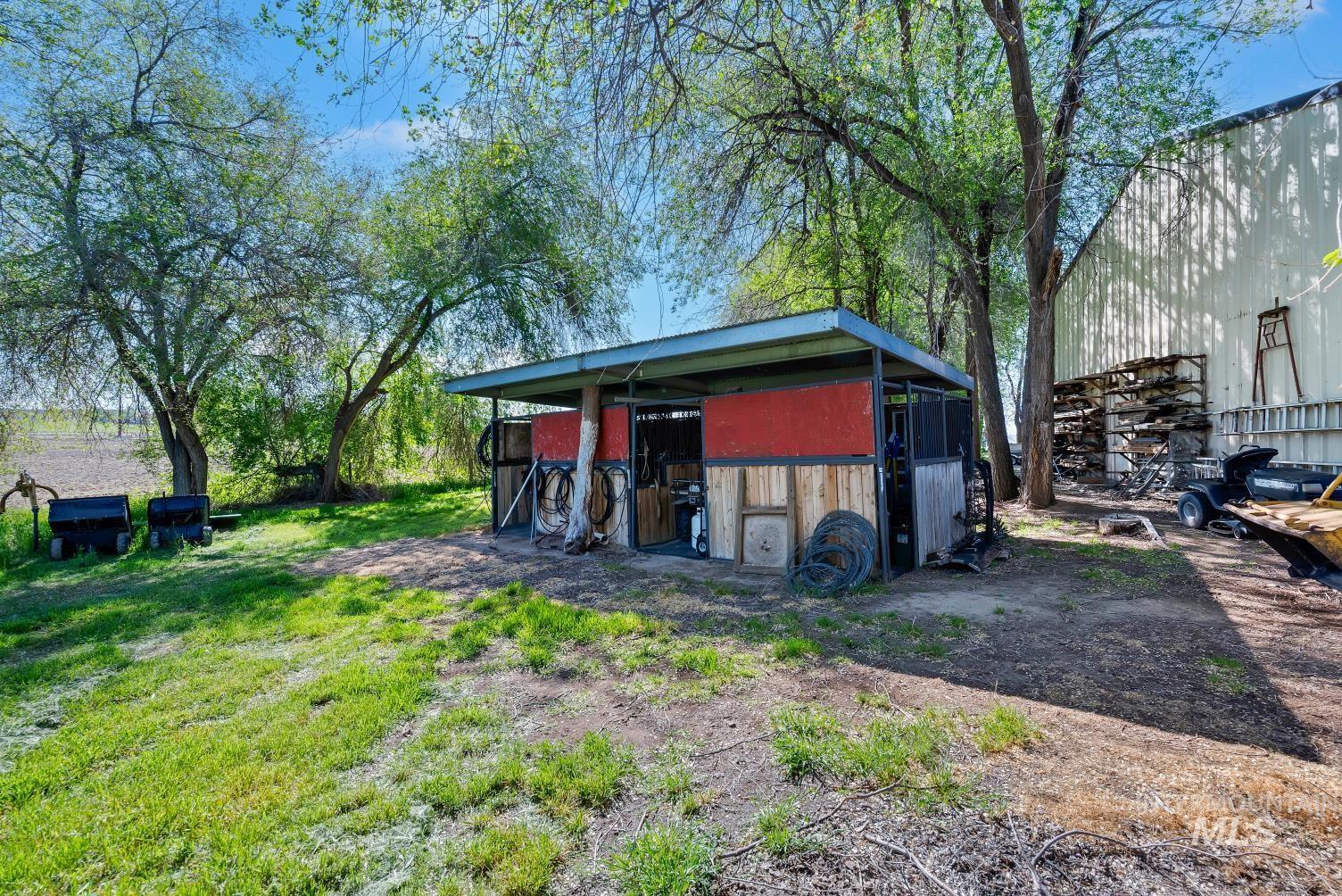19152 Marsing Road Caldwell, ID 83607 - Photo 12 of 47 Open-sided storage structure with a metal roof and painted red panels