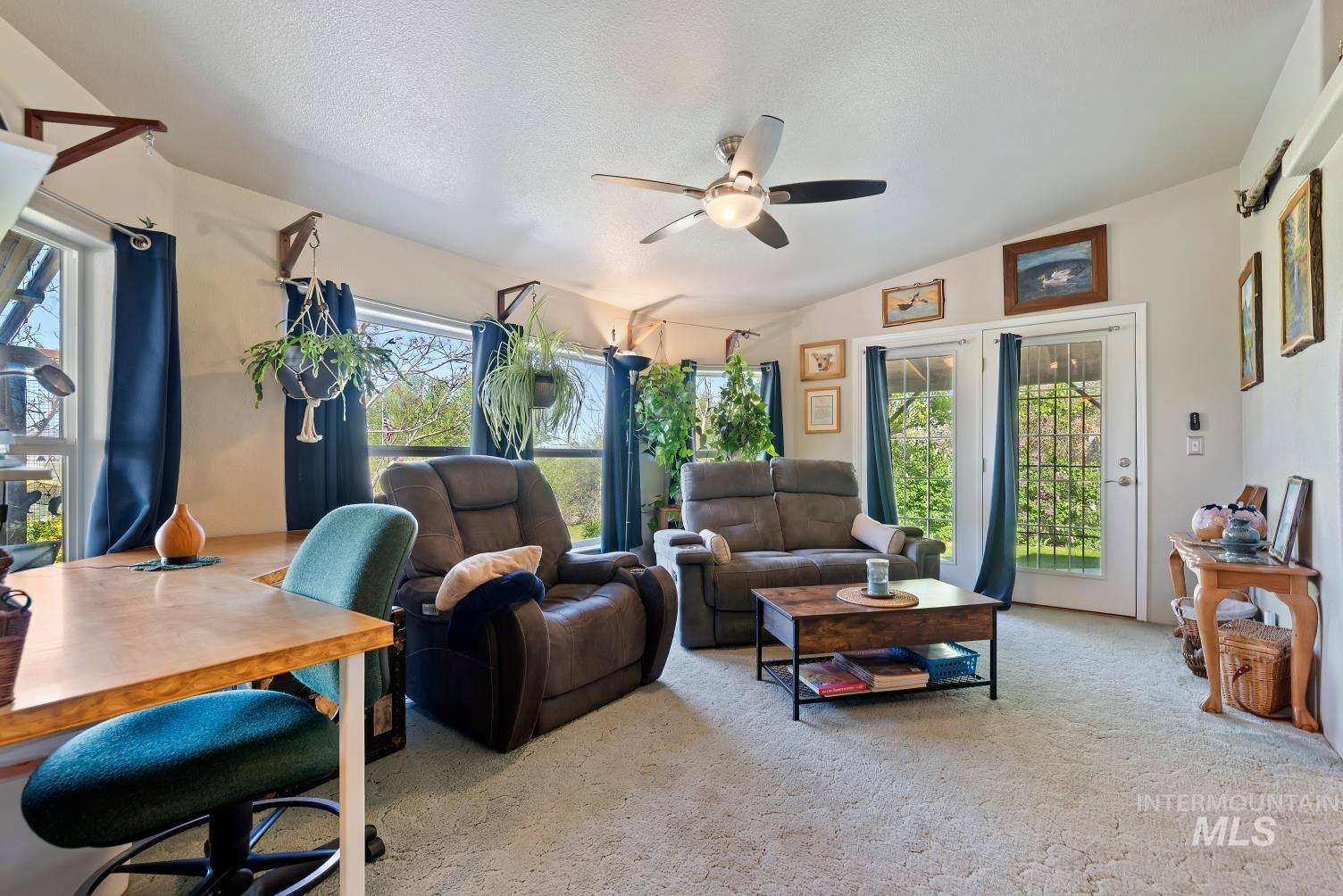 19152 Marsing Road Caldwell, ID 83607 - Photo 14 of 47 Carpeted living area featuring a vaulted ceiling with a ceiling fan