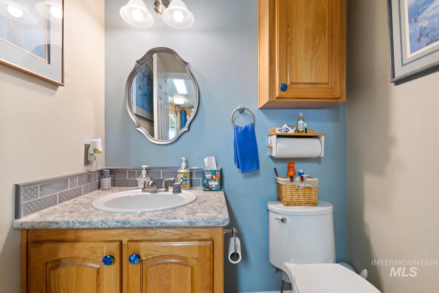 19152 Marsing Road Caldwell, ID 83607 - Photo 21 of 47 Bathroom featuring a vanity with wood-finish cabinetry, a contemporary countertop, and an oval undermount sink