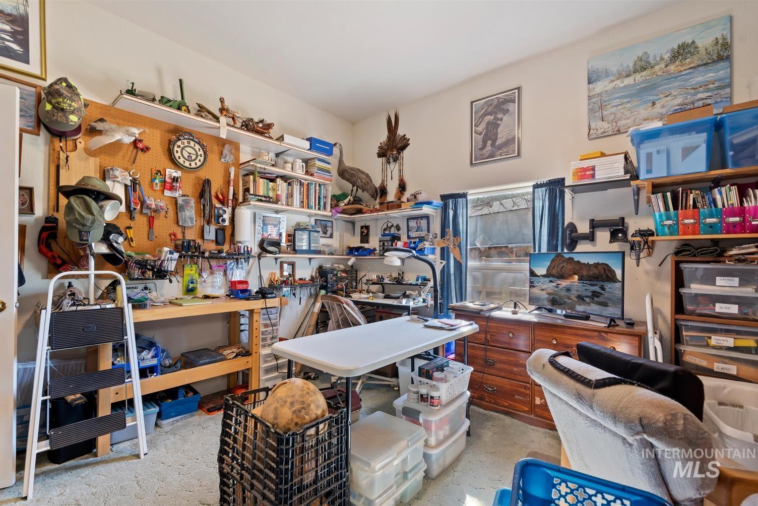 19152 Marsing Road Caldwell, ID 83607 - Photo 23 of 47 Dedicated workspace featuring built-in shelving, a wall-mounted pegboard, and dual windows