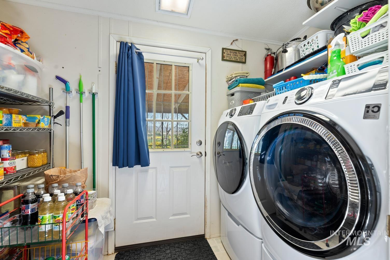 19152 Marsing Road Caldwell, ID 83607 - Photo 30 of 47 Laundry area featuring a side-by-side washer and dryer, a white paneled door with a window, wall-mounted shelving, and overhead lighting