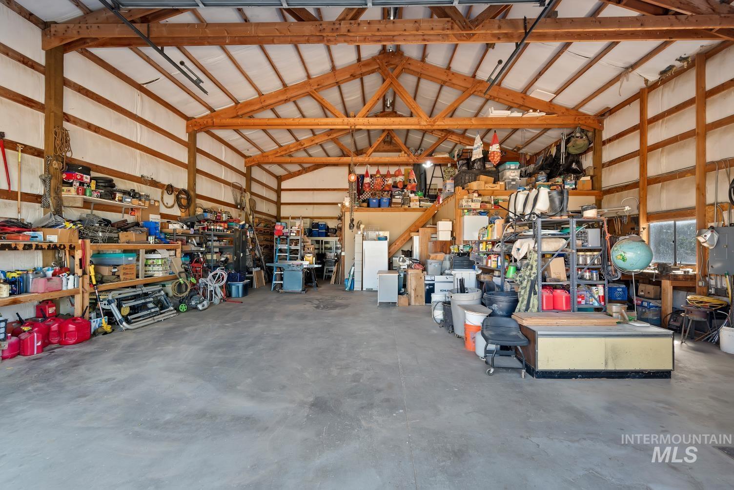 19152 Marsing Road Caldwell, ID 83607 - Photo 32 of 47 Spacious workshop featuring exposed wood beam construction, concrete flooring, and ample storage shelving