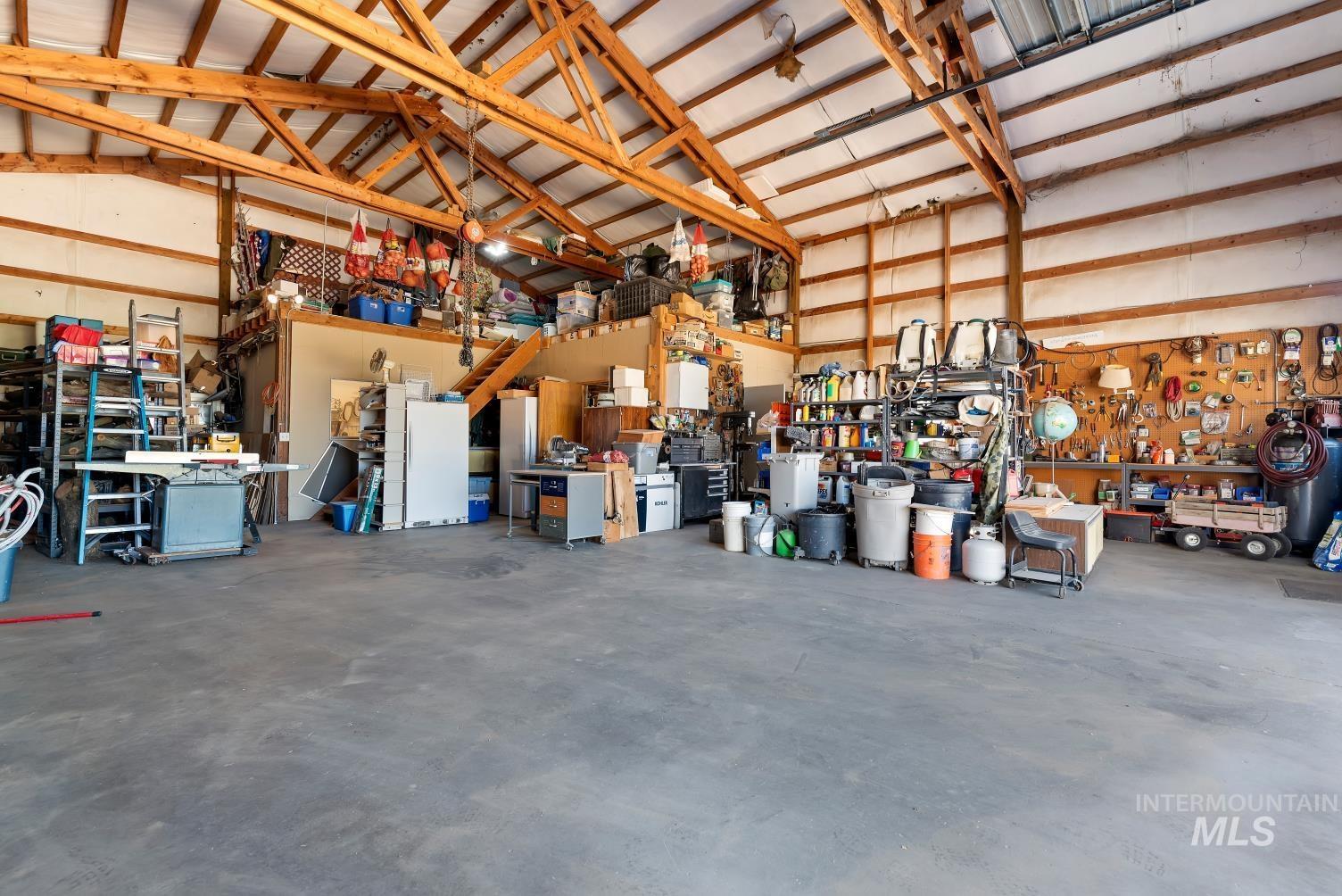 19152 Marsing Road Caldwell, ID 83607 - Photo 33 of 47 Spacious barn interior featuring exposed wood beam construction, a concrete floor, and extensive overhead storage potential
