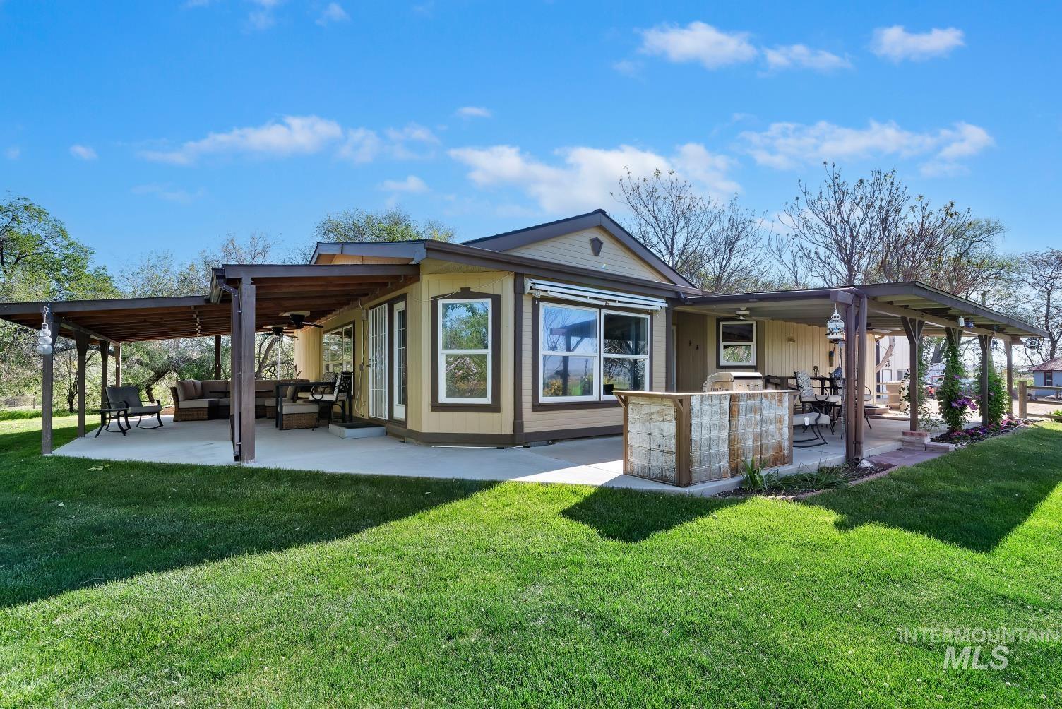 19152 Marsing Road Caldwell, ID 83607 - Photo 4 of 47 Expansive concrete patio featuring a dual pergola system with a wood-finish ceiling, offering substantial covered outdoor living space