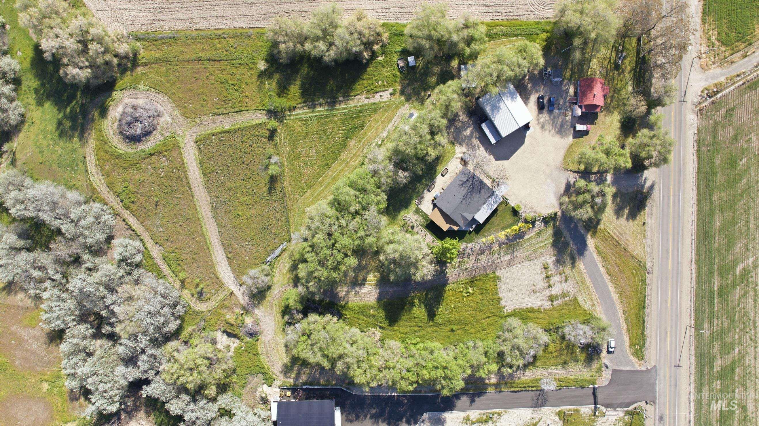 19152 Marsing Road Caldwell, ID 83607 - Photo 43 of 50 Aerial perspective showcasing a property with two structures and mature trees