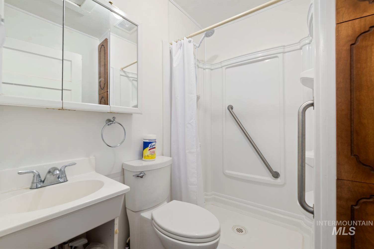 19152 Marsing Road Caldwell, ID 83607 - Photo 46 of 47 White bathroom featuring a single-piece shower stall with built-in grab bars, a white vanity with an integrated sink, and a chrome faucet