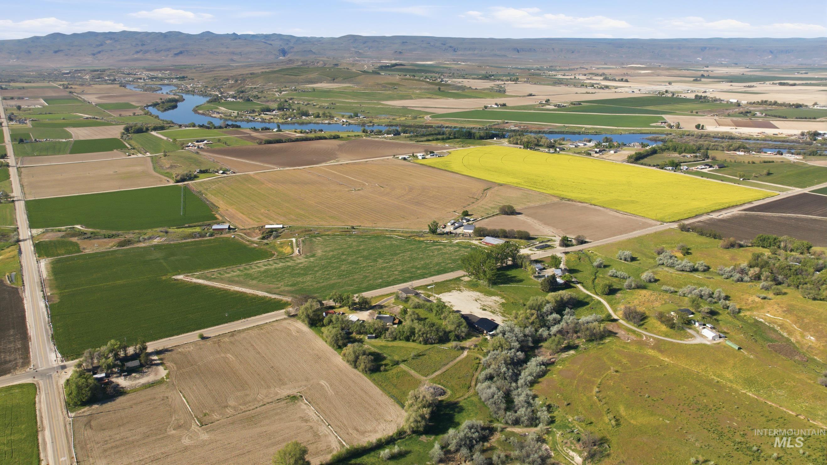 19152 Marsing Road Caldwell, ID 83607 - Photo 49 of 50 Expansive rural landscape featuring diverse agricultural fields, a meandering river, and distant mountains