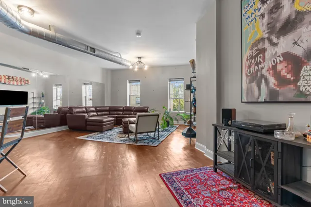 a living room with furniture and a wooden floor