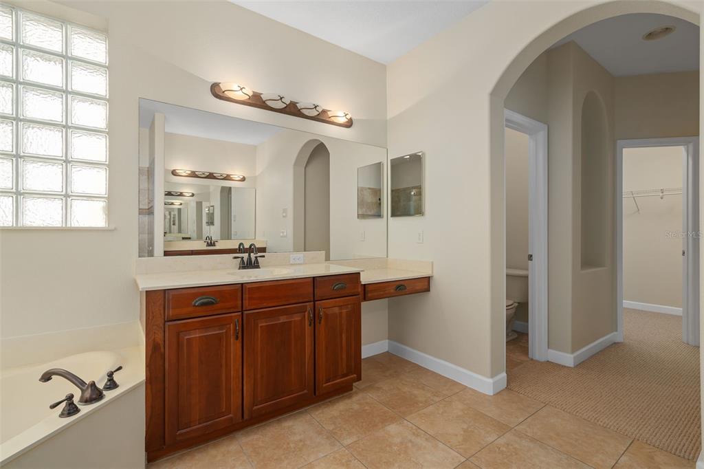 857 Timber Isle Drive Orlando, FL 32828 - Photo 16 of 54 a spacious bathroom with a double vanity sink a mirror and a bathtub
