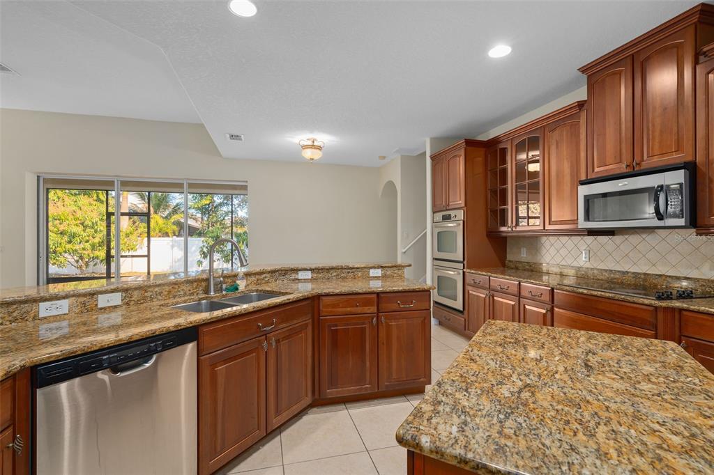 857 Timber Isle Drive Orlando, FL 32828 - Photo 18 of 54 a kitchen with lots of counter top space sink and wooden floor