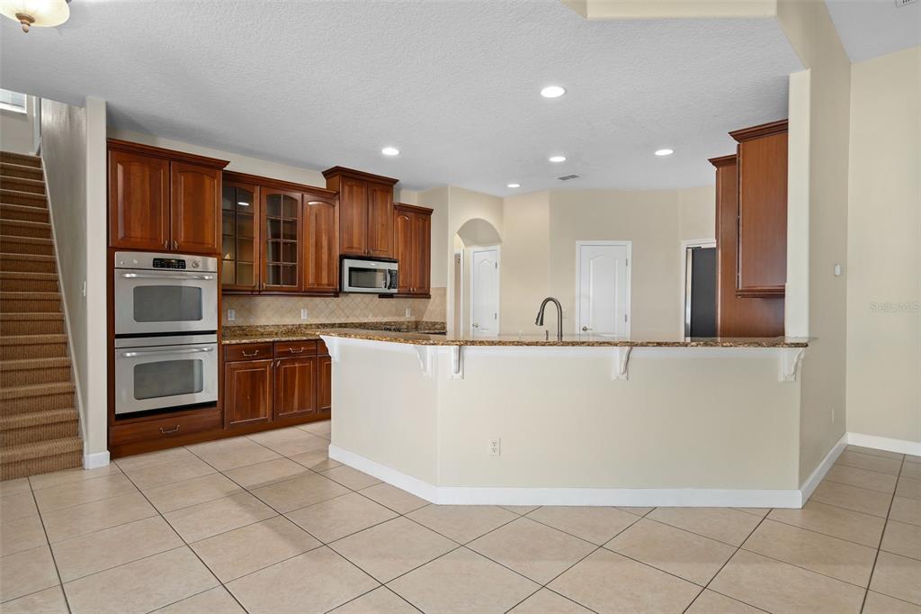857 Timber Isle Drive Orlando, FL 32828 - Photo 21 of 54 a large kitchen with stainless steel appliances a refrigerator and a stove top oven