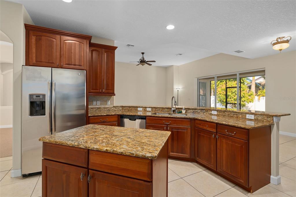 857 Timber Isle Drive Orlando, FL 32828 - Photo 24 of 54 a kitchen with kitchen island granite countertop a sink stove and refrigerator