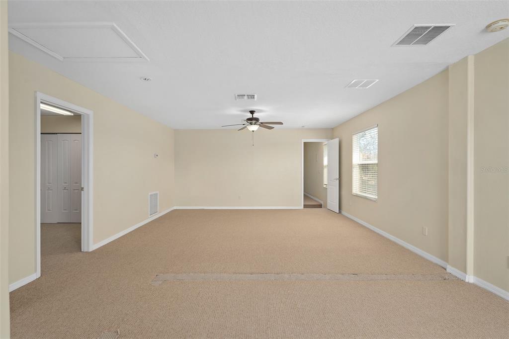 857 Timber Isle Drive Orlando, FL 32828 - Photo 33 of 54 an empty room with chandelier fan and windows