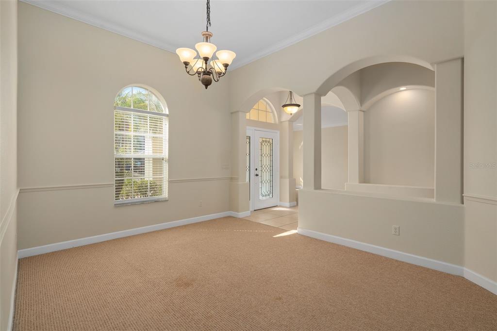 857 Timber Isle Drive Orlando, FL 32828 - Photo 8 of 54 an empty room with chandelier fan and windows