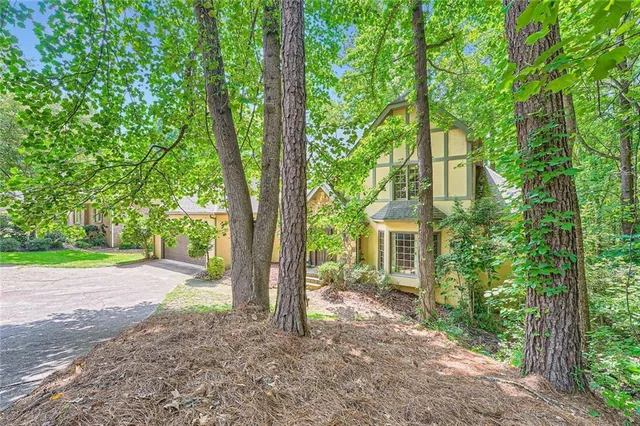 a view of a house with backyard and a tree