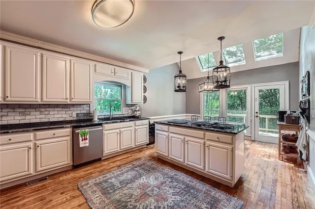 a kitchen with granite countertop a stove a sink and a refrigerator