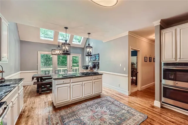 a kitchen with stainless steel appliances granite countertop a stove a sink and a refrigerator