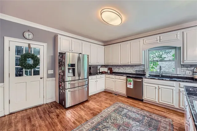 a kitchen with granite countertop a refrigerator and wooden cabinets