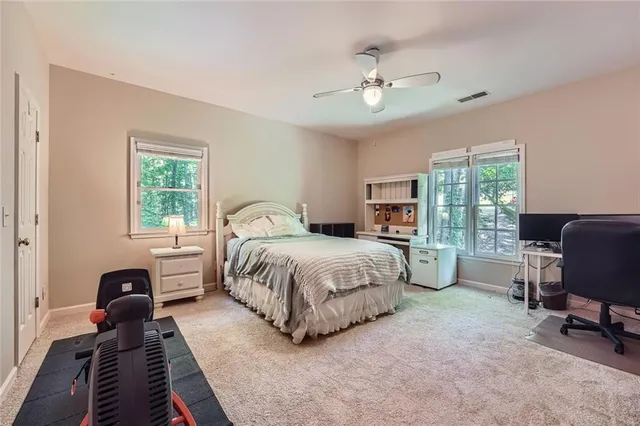 a spacious bedroom with a bed and large windows